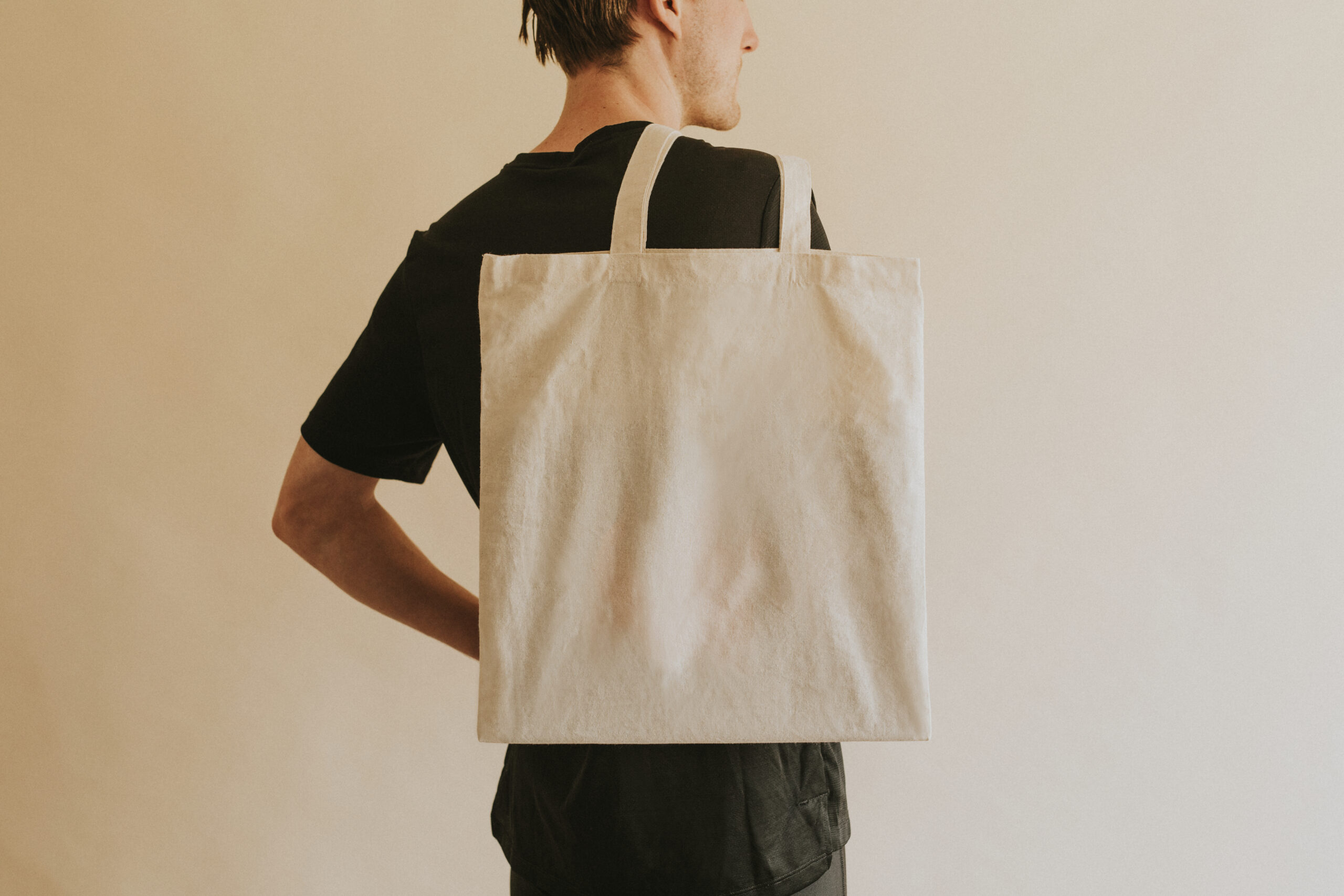 Back view man carrying tote bag