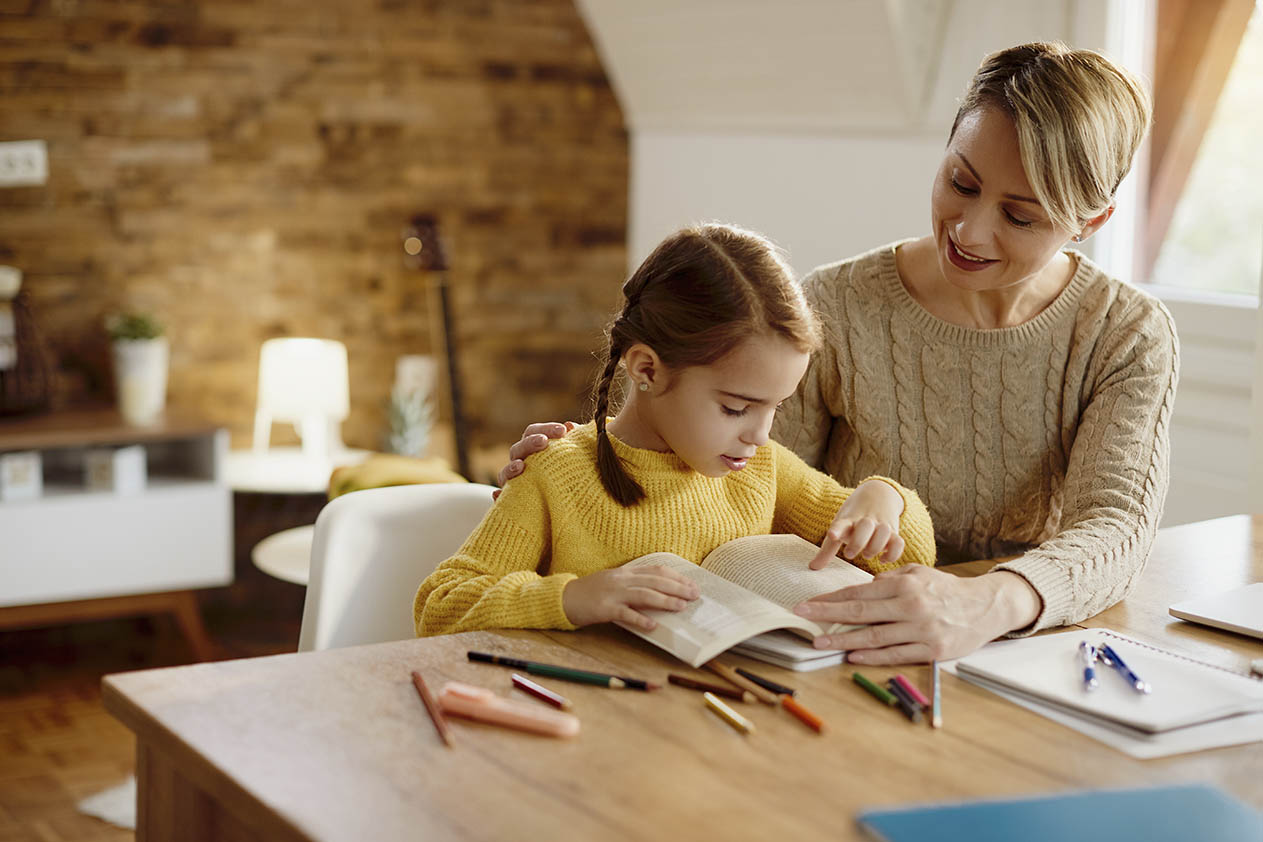 Madre enseñando a leer a su hijo